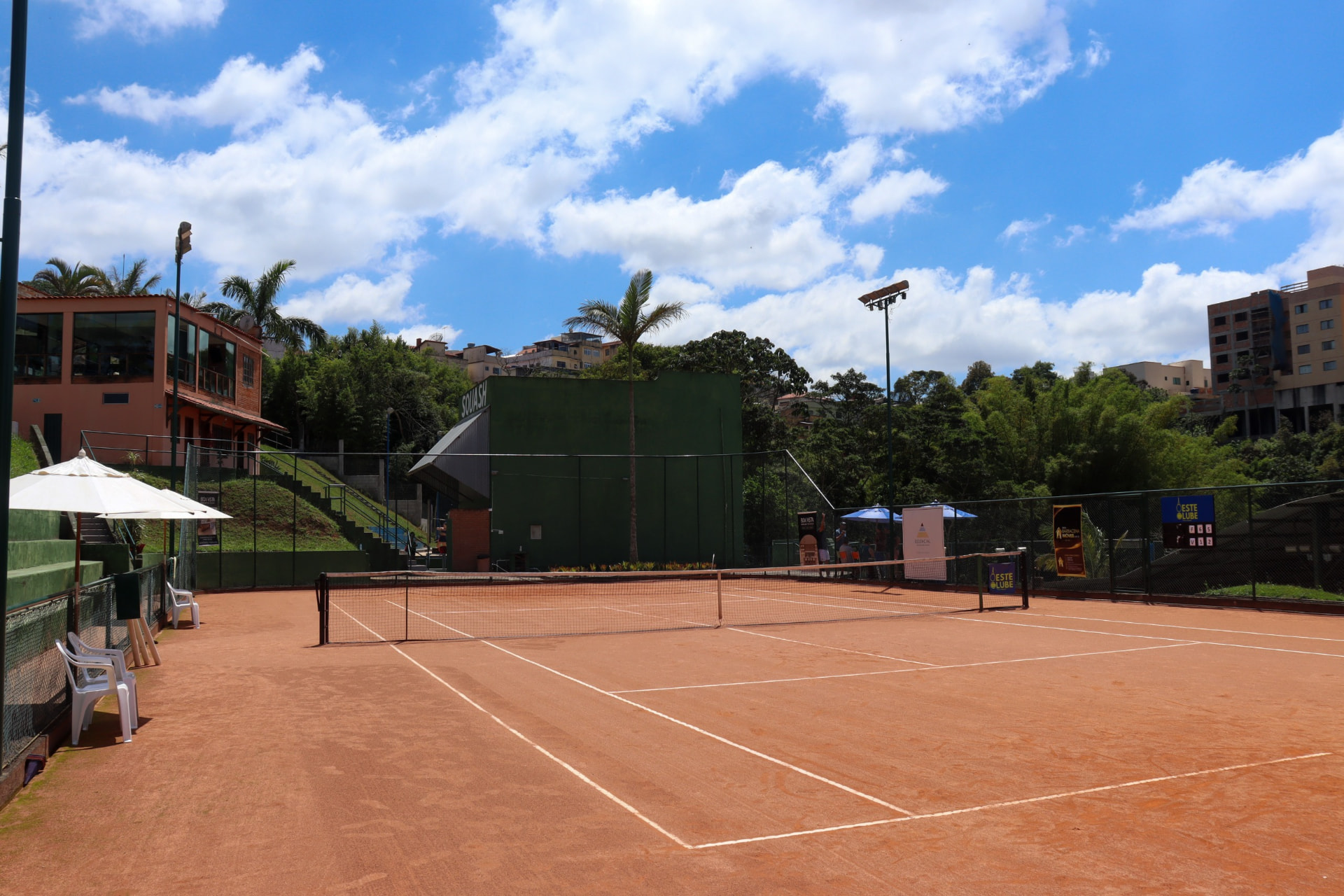 Quadra de tênis de saibro do Oeste Clube sob céu azul
